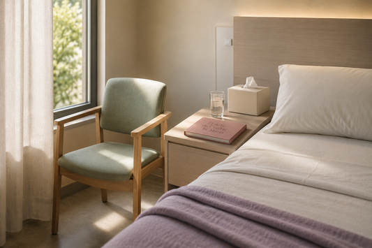 Silla junto a una cama sanitaria, pañuelos y vaso de agua en un espacio privado preparado para conversar.